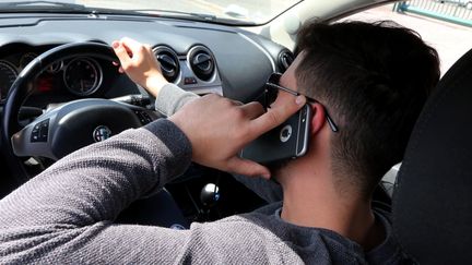 Un automobiliste téléphonant en conduisant. (JULIO PELAEZ / MAXPPP)