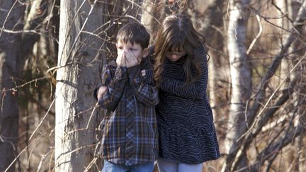 Deux enfants attendent &agrave; l'ext&eacute;rieur de l'&eacute;cole primaire Sandy Hook (Connecticut, Etats-Unis), apr&egrave;s la fusillade qui a fait au moins 27 morts, le 14 d&eacute;cembre 2012. (MICHELLE MCLOUGHLIN / REUTERS)