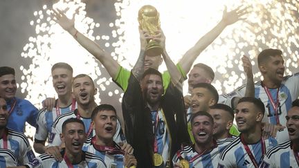 Entouré de ses coéquipiers, Lionel Messi, capitaine de l'équipe d'Argentine, porte la Coupe du monde après la victoire contre l'équipe de France de football, le 18 décembre 2022. (HASAN BRATIC / HASAN BRATIC)