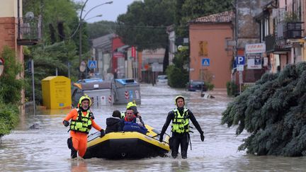 Des secouristes aident des personnes à Coccolia (Italie), après des inondations causées par des pluies diluviennes, le 17 mai 2023. (PASQUALE BOVE / MAXPPP)