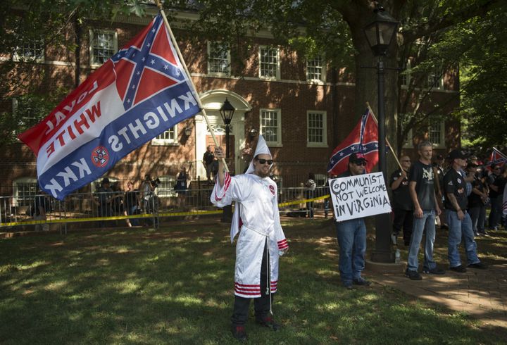 Des membres du Ku Klux Klan manifestent à Charlottesville (Virginie, Etats-Unis), le 8 juillet 2017. Certains agitent des drapeaux confédérés. (ANDREW CABALLERO-REYNOLDS / AFP)