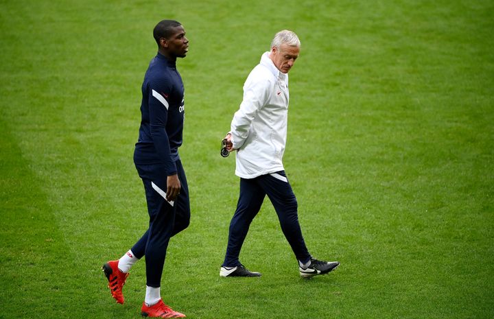 Paul Pogba, ici aux côtés du sélectionneur français Didier Deschamps, n'a pas participé à la séance collective des Bleus, lundi 28 mars 2022, à la veille du match amical contre l'Afrique du Sud. (FRANCK FIFE / AFP)