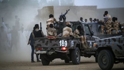 Des membres de la Force de soutien rapide du Soudan sont à l'arrière d'une camionnette équipée d'une tourelle de mitrailleuse lors d'un rassemblement dans le village de Qarri, à environ 90 kilomètres au nord de Khartoum, le 15 juin 2019. (- / AFP)