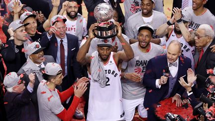 Le joueur des Raptors&nbsp;Kawhi Leonard brandit le trophée de la conférence Est, dimanche 26 mai 2019 à Toronto (Canada), avec déjà en ligne de mire la finale de la Ligue, à partir de jeudi prochain. (CLAUS ANDERSEN / GETTY IMAGES NORTH AMERICA / AFP)