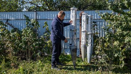 Un paysan ukrainien expose des roquettes à sous-munitions découvertes dans son champ de Zeleniy Hai, dans l'oblast de Kherson, dans le sud de l'Ukraine, le 16 octobre 2022. (VIRGINIE NGUYEN HOANG / HANS LUCAS / AFP)