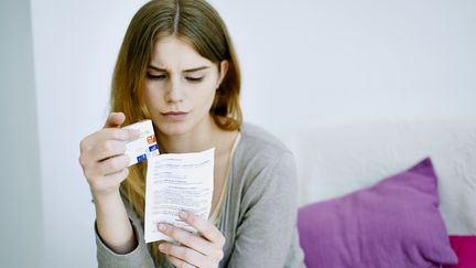 Une femme regarde la notice d'un antidépresseur, le 8 juillet 2015. (ALICE S. / BSIP / AFP)