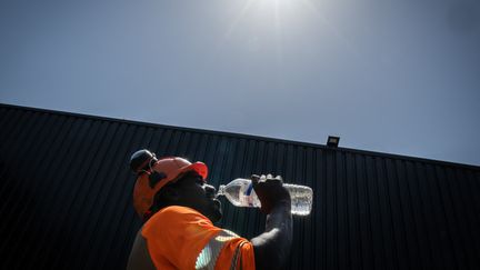 Un travailleur boit sous un soleil caniculaire, à Savernay (Loire-Atlantique). (LOIC VENANCE / AFP)