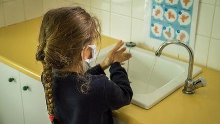 Une élève se lave les mains dans une école. Photo d'illustration. (JEAN-FRANÇOIS FERNANDEZ / FRANCE-BLEU BESANÇON)