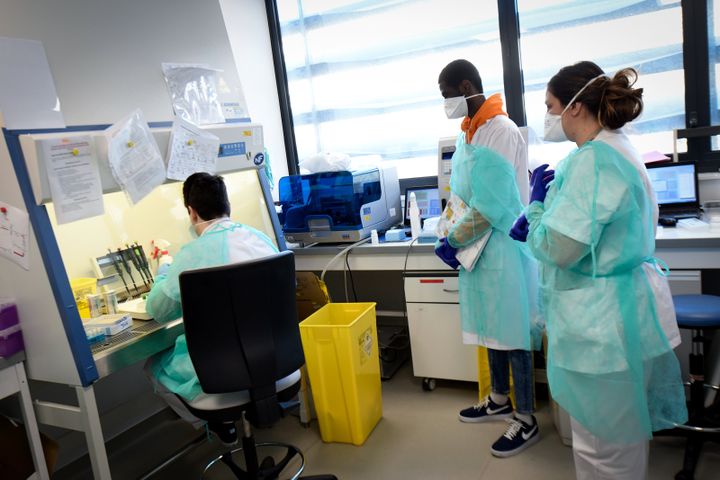 Du personnel médical teste&nbsp;un échantilon prélevé chez un patient potentiellement atteint de Covid-19, le 26 février 2020 dans un laboratoire de l'IHU de Marseille. (GERARD JULIEN / AFP)