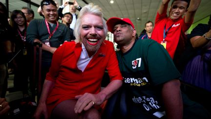 Le milliardaire britannique Richard Branson (G) grim&eacute; en h&ocirc;tesse de l'air, et le patron d'AirAsia, Tony Fernandes, &agrave; l'a&eacute;roport de Kuala Lumpur (Malaisie), le 12 mai 2013. (MOHD RASFAN / AFP)