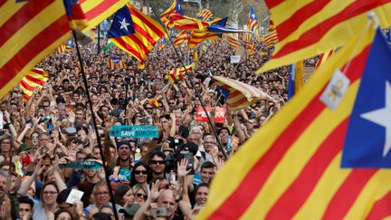 Des partisans de l'indépendance de la Catalogne regardent la session du Parlement catalan sur des écrans géants à Barcelone, le 27 octobre 2017. (YVES HERMAN / REUTERS)