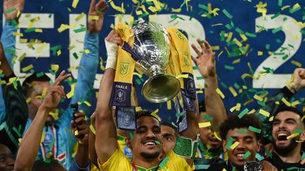 Le capitaine nantais Ludovic Blas soulève le trophée de la Coupe de France, le 7 mai 2022 au Stade de France. (FRANCK FIFE / AFP)