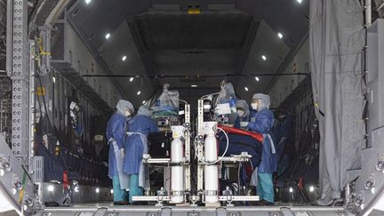 Des soignants vérifient les équipements médicaux installés dans un Airbus A400M avant une évacuation de patients infectés par le nouveau coronavirus sur la base aérienne de Matoury, près de Cayenne, le 28 juin 2020. (JODY AMIET / AFP)