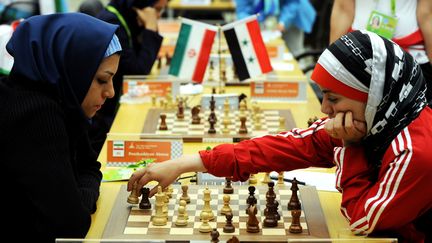 Atous Pourkashiyan, Iranienne et&nbsp;Fatemah Al-Jeldah, Syrienne, jouent une partie d'échecs lors des Jeux asiatiques, le 18 novembre 2010, à&nbsp;Canton (Chine). (GOH CHAI HIN / AFP)