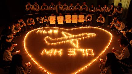 Des familles des passagers chinois du vol MH370 de la Malaysia Airlines, disparu d&eacute;but mars 2014, prient, le 10 mars 2014 &agrave;&nbsp;Zhuji (Chine). ( AFP )