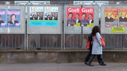 Une personne passe, le 15 mars 2011 devant des panneaux &eacute;lectoraux install&eacute;s dans le centre ville de Strasbourg, &agrave; l'occasion des &eacute;lections cantonales des 20 et 27 mars. (FREDERICK FLORIN / AFP)