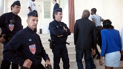 Policiers et proches des tireurs présumés à l'entrée de la cour d'assises du Val-d'Oise - 02/07/10 (AFP Bertrand Langlois)