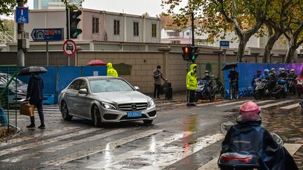 Des policiers (en jaune) montent la garde à Shanghai (Chine), le 29 novembre 2022.&nbsp; (HECTOR RETAMAL / AFP)