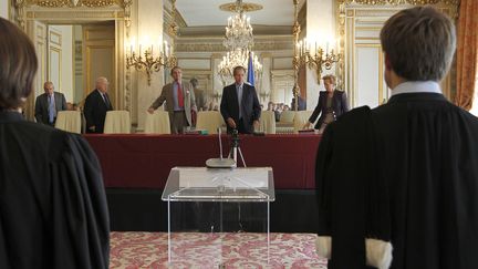 Le pr&eacute;sident du Conseil constitutionnel, Jean-Louis Debr&eacute; (au centre), s'appr&ecirc;te &agrave; rendre publique la d&eacute;cision de l'instance sur la r&eacute;forme de la garde &agrave; vue, le 20 juillet 2010 &agrave; Paris. (FRANCOIS GUILLOT / AFP)