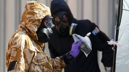 Des membres de la police scientifique, en tenue protectrice, travaillent au domicile d'un homme empoisonné au Novitchok, le 6 juillet 2018, à Amesbury (Angleterre). (HENRY NICHOLLS / REUTERS)