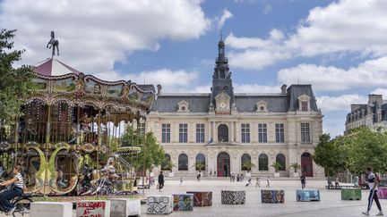 Des passants marchent devant la mairie de Poitiers (Vienne), le 31 juillet 2023. (ANTOINE BOUREAU / HANS LUCAS / AFP)