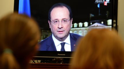 Une famille regarde &agrave; la t&eacute;l&eacute;vision les v&oelig;ux du pr&eacute;sident de la R&eacute;publique, Fran&ccedil;ois Hollande, le 31 d&eacute;cembre 2013, &agrave; Rennes (Ille-et-Vilaine). (DAMIEN MEYER / AFP)