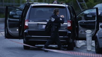 Une polici&egrave;re intervient &agrave; proximit&eacute; de la voiture o&ugrave; a &eacute;t&eacute; tu&eacute;e l'h&eacute;riti&egrave;re mon&eacute;gasque H&eacute;l&egrave;ne Pastor, le 6 mai 2014, &agrave; Nice (Alpes-Maritimes). (VALERY HACHE / AFP)