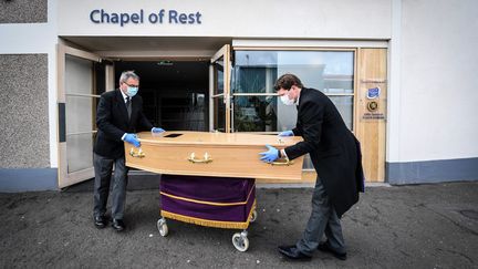 Des employés des pompes funèbres déplacent le cerceuil d'une femme morte du Covid-19 à&nbsp;Ferryden, en Ecosse, le 4 mai 2020. (ANDY BUCHANAN / DIGITAL / AFP)