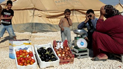 Dans le camp de Zaatari, en Jordanie, une femme vend des l&eacute;gumes, le 3 janvier 2013. (KHALIL MAZRAAWI / AFP)