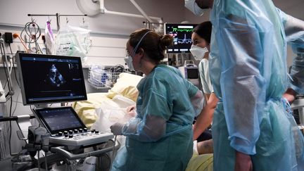 Des soignantes au chevet d'un patient atteint par le Covid-19, le 5 mai 2021 à Colombes (Hauts-de-Seine). (ALAIN JOCARD / AFP)