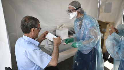 Un habitant de Seine-Saint-Denis testé pour le Covid-19 sur un site de test mobile gratuit à Clichy-sous-Bois le 22 mai 2020. (STEPHANE DE SAKUTIN / AFP)