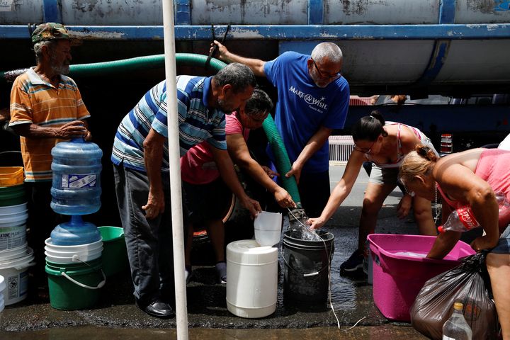 Des habitants de Porto Rico remplissent des bidons d'eau, le 26 septembre 2017.&nbsp; (CARLOS GARCIA RAWLINS / REUTERS)