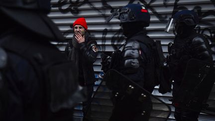 Un homme est retenu par les forces de l'ordre, le 14 avril 2023, à Paris. (JULIEN DE ROSA / AFP)