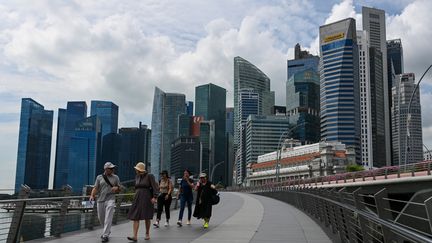 Passers-by on the Jubilee Bridge on the Singapore waterfront, November 17, 2023. (ROSLAN RAHMAN / AFP)