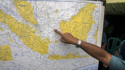 Un officier de l'aviation indon&eacute;sienne montrant la zone de la mer de Java o&ugrave; sont concentr&eacute;s les recherches pour localiser l'Airbus de la compagnie AirAsia, port&eacute; disparu depuis dimanche 28 d&eacute;cembre 2014, avec 162 personnes &agrave; bord. (JUNI KRISWANTO / AFP)