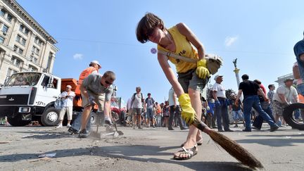 Des habitants de Kiev nettoient la place Maidan o&ugrave; s'&eacute;l&egrave;vent encore des barricades, samedi 9 ao&ucirc;t 2014.&nbsp; (SERGEI SUPINSKY / AFP)