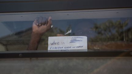 "Que fait la Cours europ&eacute;enne des droits de l'homme" ? peut-on lire sur une feuille de papier, brandie par un migrant qui a &eacute;t&eacute; embarqu&eacute; par la police, apr&egrave;s l'&eacute;vacuation muscl&eacute;e de la halle Pajol, dans le 18e arrondissement de Paris, le 8 juin 2015.&nbsp; (LAURENCE GEAI / SIPA)