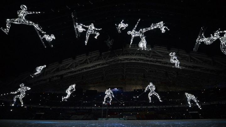 Des figures repr&eacute;sentant diff&eacute;rentes disciplines sportives scintillent dans le stade de Sotchi (Russie) pour l'ouverture des JO, le 7 f&eacute;vrier 2014. (ALBERTO PIZZOLI / AFP)