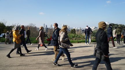 Des promeneurs dans le parc des Buttes Chaumont, à Paris, en mars 2020. (MYRIAM TIRLER / HANS LUCAS)