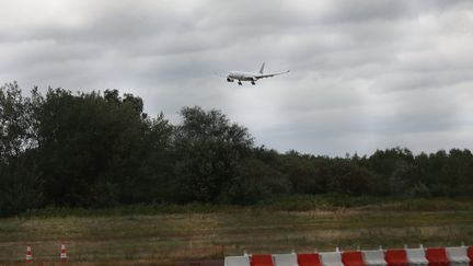 Un avion atterrit à l'aéroport de Roissy, près de Paris, le 2 août 2023. (MOHAMAD SALAHELDIN ABDELG ALSAYE / ANADOLU AGENCY / AFP)