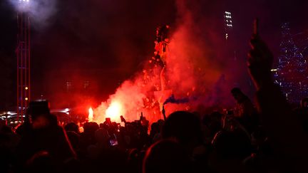 Des supporters de l'équipe de France de football fête la victoire des Bleus face à l'Angleterre en  quart de finale de la Coupe du monde au Qatar, samedi 10 décembre 2022. (SYLVAIN THOMAS / AFP)