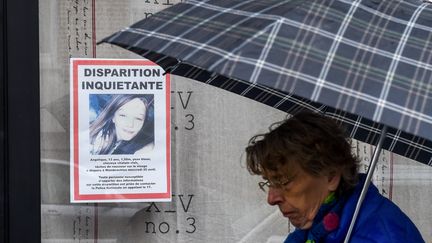 Une femme passe devant un avis de disparition de la jeune Angélique à&nbsp;Wambrechies (Nord), le 29 avril 2018. (PHILIPPE HUGUEN / AFP)