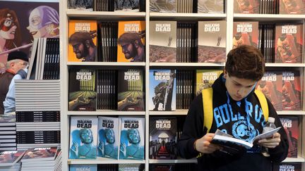 Un garçon en pleine lecture d'une BD américaine au Festival de la BD d'Angoulème en 2014
 (NICOLAS TUCAT / AFP)