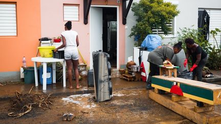 Des habitants constatent les dégâts après le passage de la tempête Fiona, le 18 septembre 2022, à Goyave. (CARLA BERNHARDT / AFP)