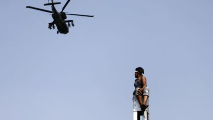 Un manifestant observe un h&eacute;licopt&egrave;re de l'arm&eacute;e &eacute;gyptienne, le 2 juillet 2013, au Caire. Les Etats-Unis ont annonc&eacute; le 9 octobre 2013 qu'ils ne livreront plus d'h&eacute;licopt&egrave;res Apache &agrave; l'Egypte. (MAHMUD KHALED / AFP)