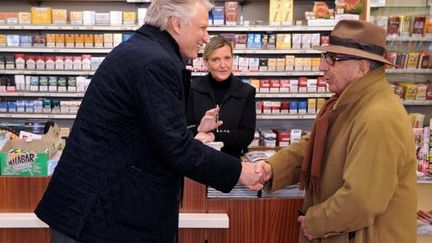 Dominique de Villepin, le 11 janvier 2012, à Périgueux, salue un client dans un bureau de tabac. (PIERRE ANDRIEU / AFP)