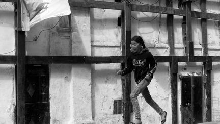 Dans la Casbah d’Alger, cette petite fille court sur un parapet devant le drapeau algérien sur lequel est écrit "One, Two, Three, viva l’Algérie !" (Lotfi Mokdad)