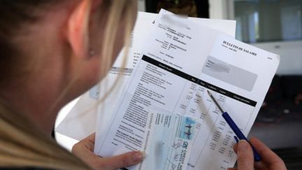 Une femme vérifie son bulletin de salaire, le 23 septembre 2021. Photo d'illustration. (AFP)