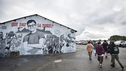 Les amis de Steve Maia Caniço s'en vont après s'être rassemblés le 30 juillet 2019 à Nantes à côté d'une murale représentant un portrait du jeune homme retrouvé mort lundi 29 juillet 2019. (LOIC VENANCE / AFP)