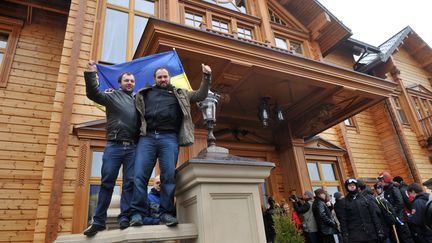 Des opposants au pr&eacute;sident ukrainien Viktor Ianoukovitch exultent devant la r&eacute;sidence du chef d'Etat, samedi 22 f&eacute;vrier 2014 dans la banlieue de Kiev. (GENYA SAVILOV / AFP)